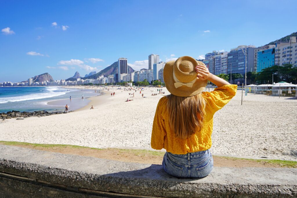 Beautiful,Young,Woman,Sitting,On,Wall,Enjoying,The,Cityscape,Of